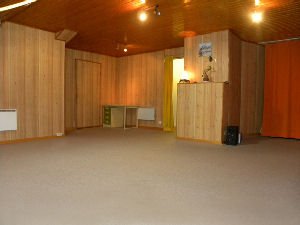 Autre vue de la salle en bois, avec une porte et un petit bureau